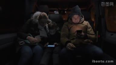 三个人晚上坐小巴，母子玩手机，一个男乘客上网